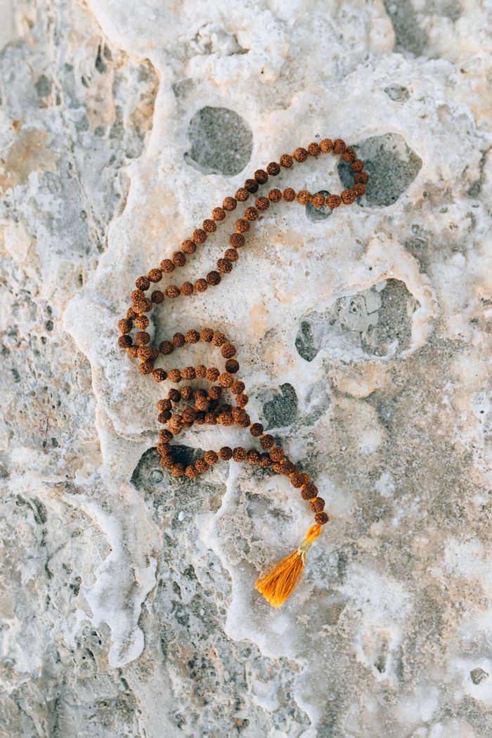 services-05 Close-up of meditation beads on a textured stone surface for a calming and spiritual vibe.