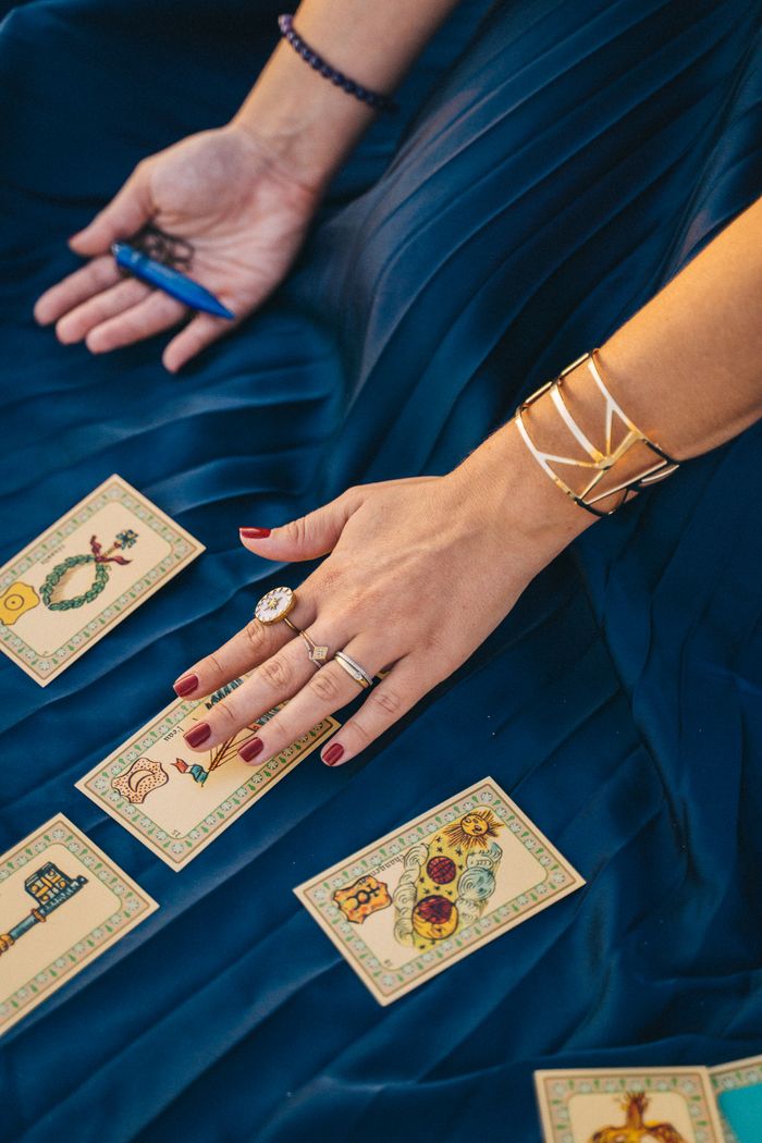 about-04 Elegant tarot card reading session with hands, jewelry, and mystical atmosphere.
